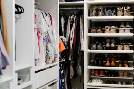 10 Truques de Organização que Toda Dona de Casa Precisa Saber a walk in closet filled with lots of shoes