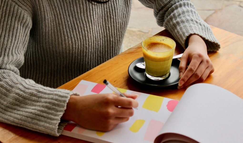 Como Organizar um Cardápio Semanal que Economiza Tempo e Dinheiro person holding pen with coffee on table