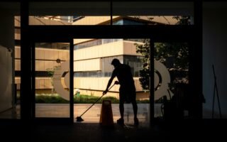silhouette of man standing near glass window during daytime