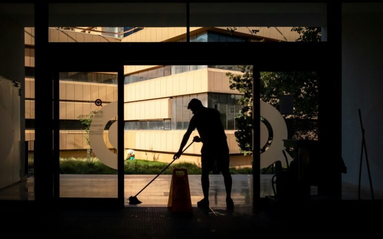 silhouette of man standing near glass window during daytime