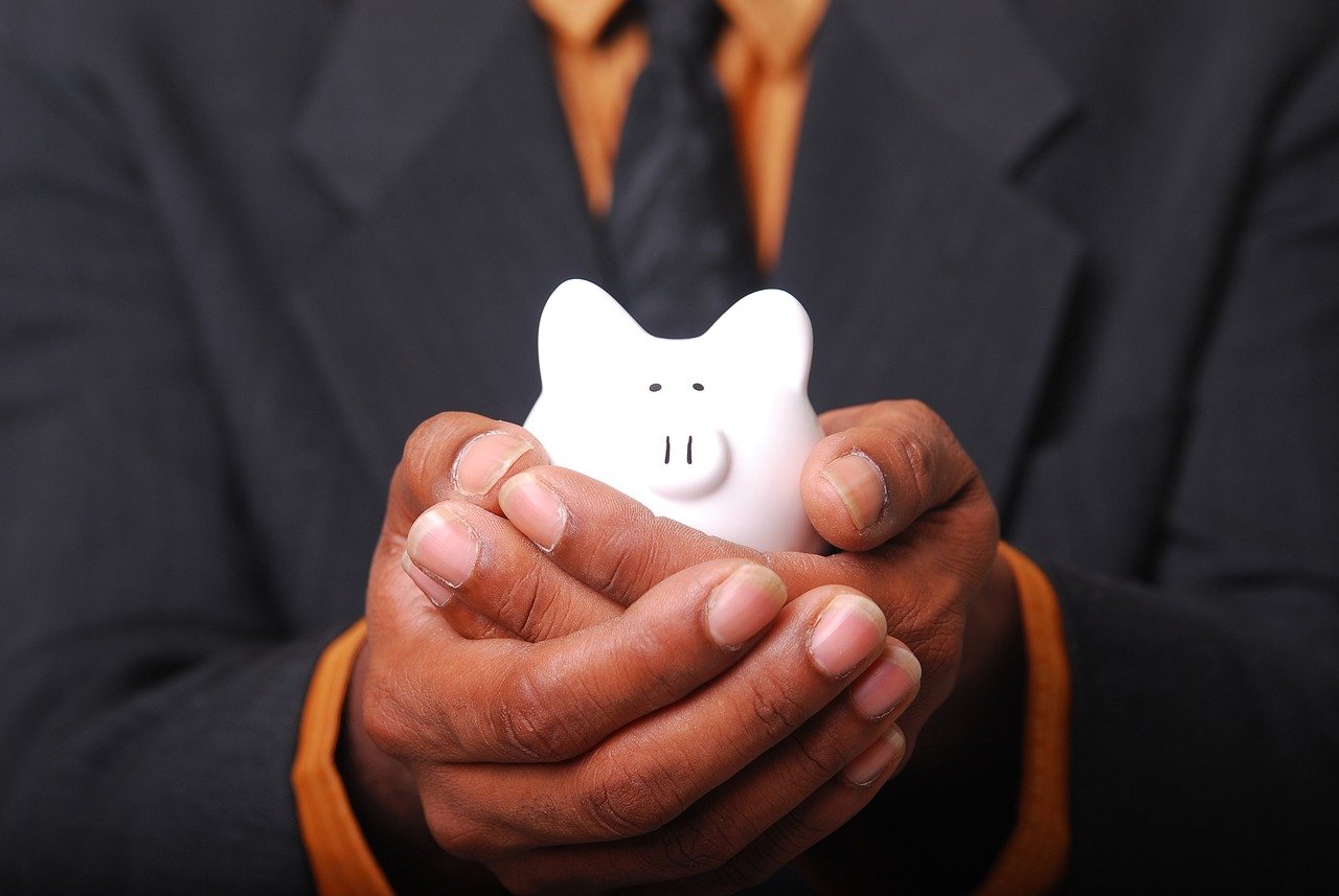 homem segurando um porquinho, suas economias de Renda Extra em 2025