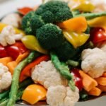 Quanto tempo cozinhar cada legume? Guia completo para não errar no ponto A vibrant assortment of fresh vegetables including broccoli, asparagus, and bell peppers.