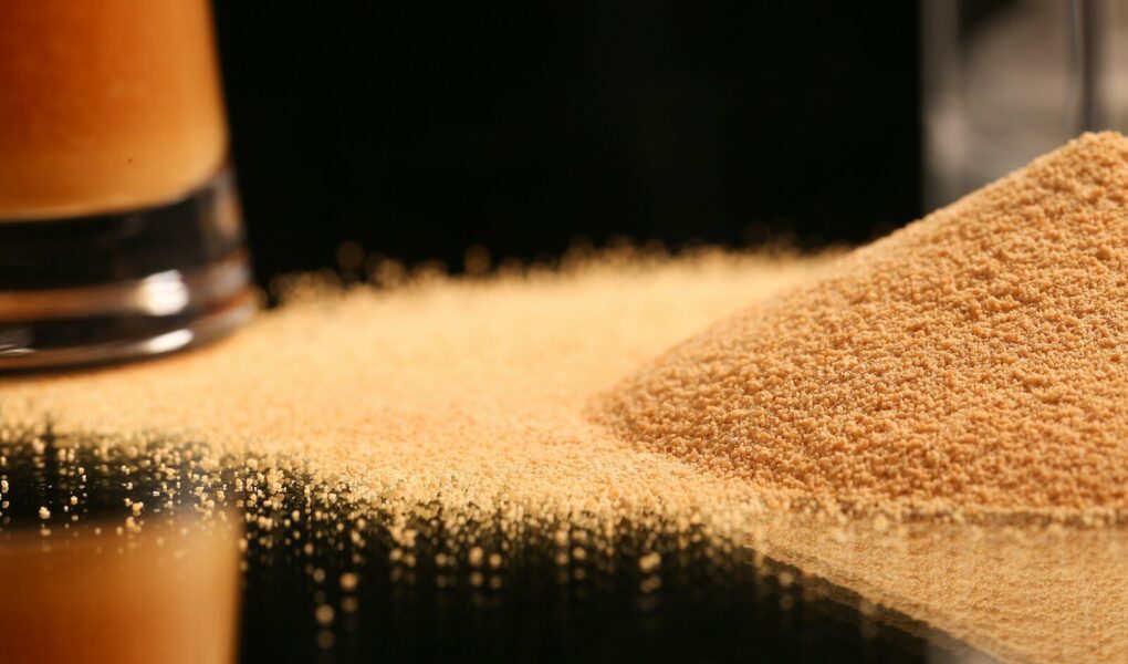 a pile of sand next to a glass of beer