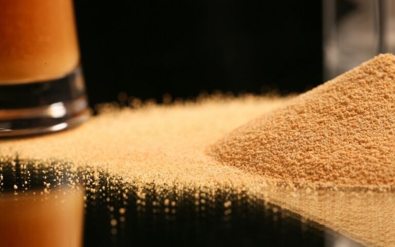 a pile of sand next to a glass of beer
